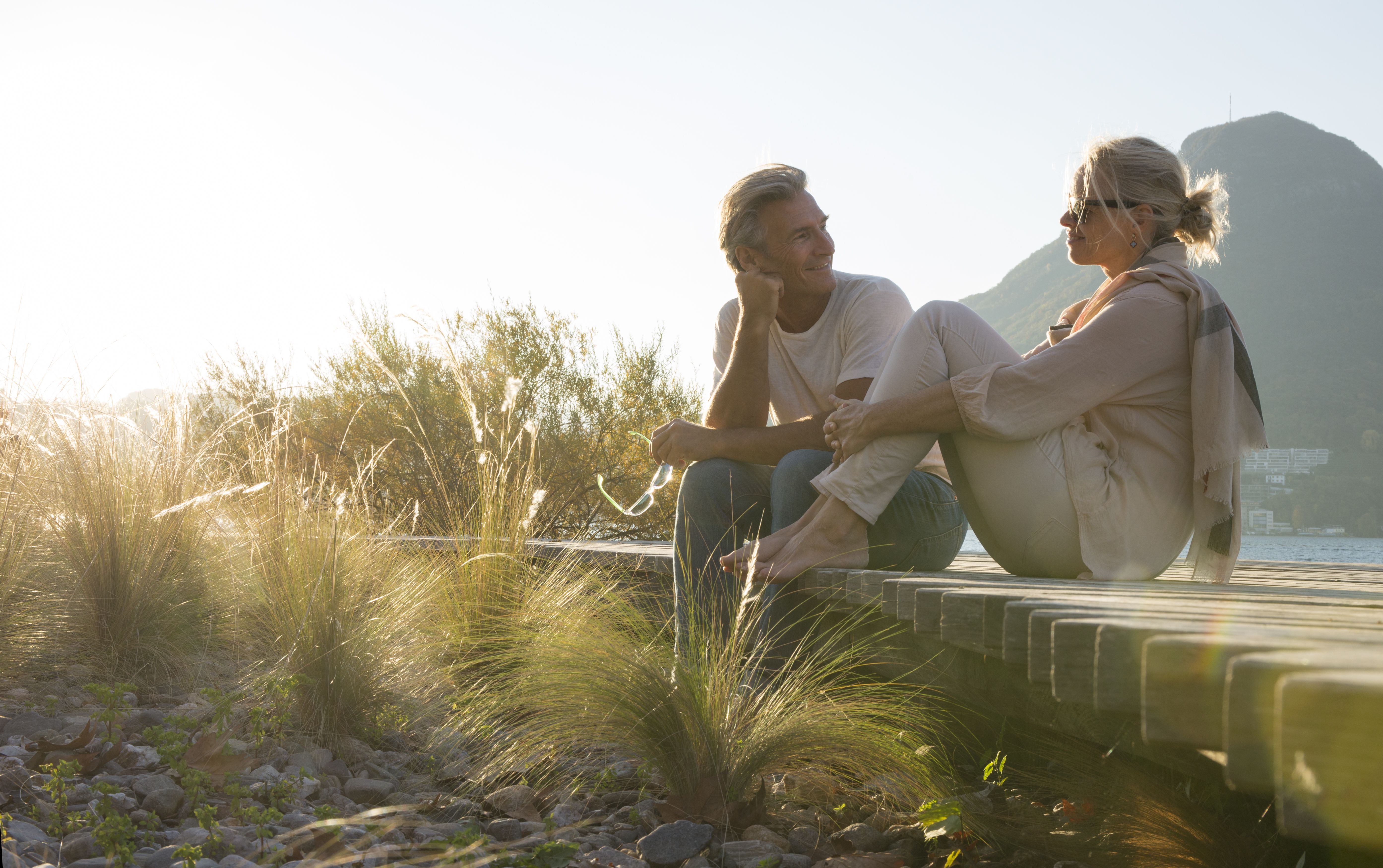 Man en vrouw die buiten met elkaar praten met een berglandschap op de achtergrond.