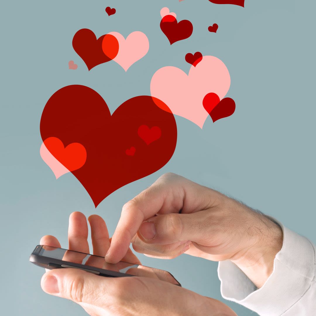 Hand van een man die een smartphone vasthoudt met hartjes op het scherm.